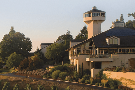 A building with a tower, surrounded by trees and landscaping.