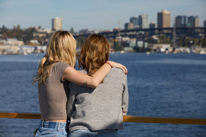 a woman standing next to a body of water