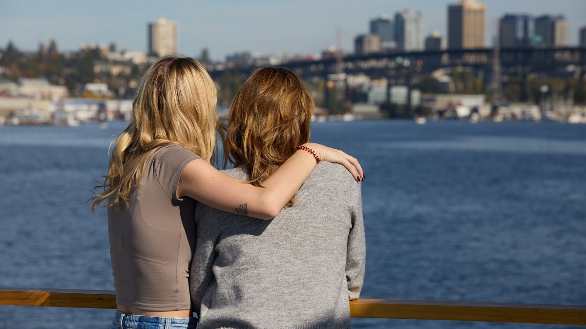 a woman standing next to a body of water