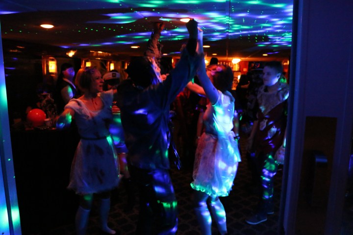 People dancing under colorful disco lights at a party.