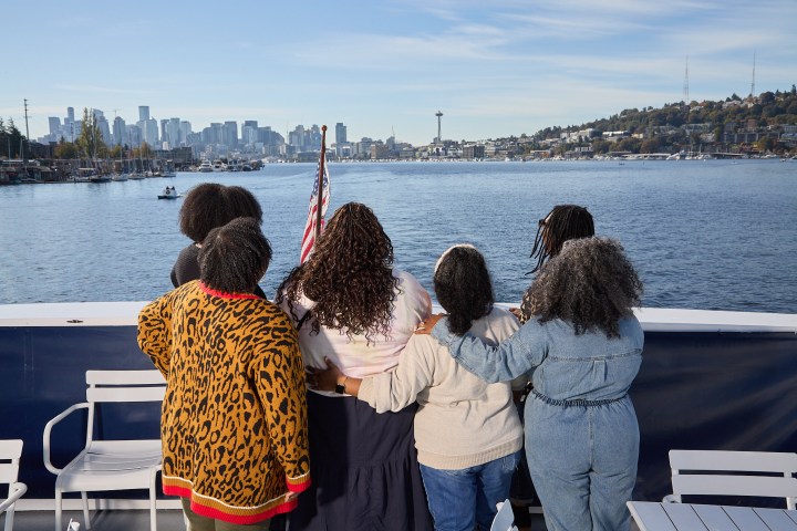 a group of people standing in front of a body of water
