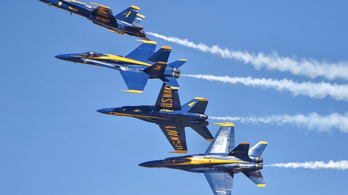 a group of fighter jets flying through a blue sky