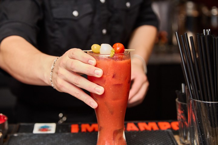 a hand holding a glass of orange juice